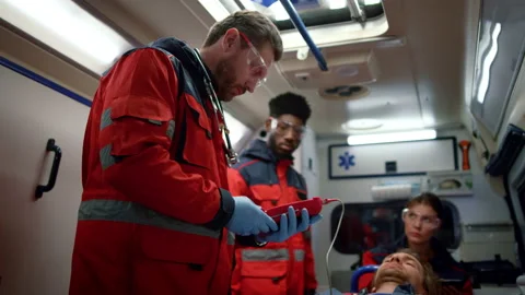 Mixed race paramedics checking oxygen blood saturation level of patient Stock Footage 166865949
