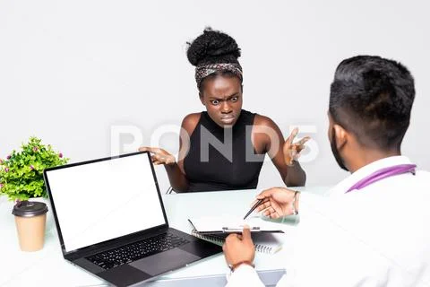 Mixed race Physician in medical practice with patients. Conversation and advi Stock Photos
