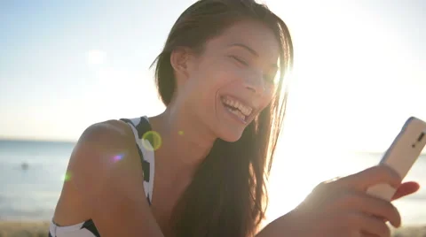 Mixed race pretty smiling young woman holding and looking at smart phone Video stock 48042637