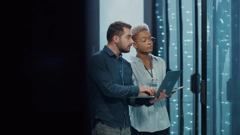 Mixed-race professional IT team cooperating in data center,. Attractive male and Video stock 121224769