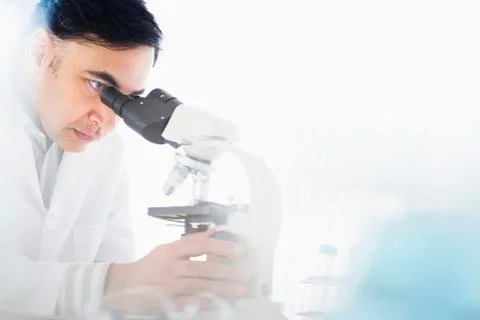 Mixed race scientist using microscope Stock Photos