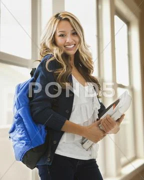 Mixed race student carrying books on campus Stock Photos