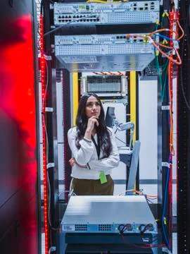 Mixed race technician examining computer in server room Stock Photos