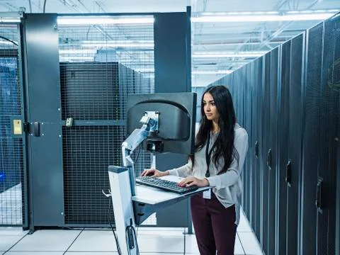 Mixed race technician using computer in server room Stock Photos