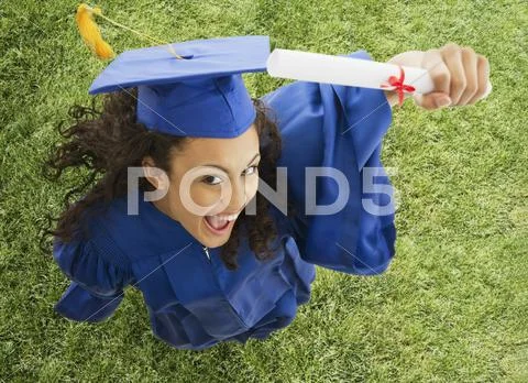 Mixed race teenage girl cheering with graduation diploma Stock Photos