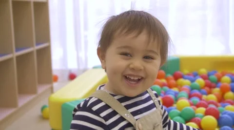 Mixed race Toddler throwing balls at the camera slow mo Vídeo Stock 58375416