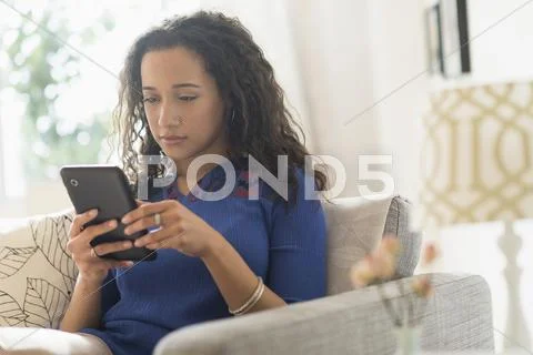 Mixed Race Woman Using Digital Tablet On Sofa
