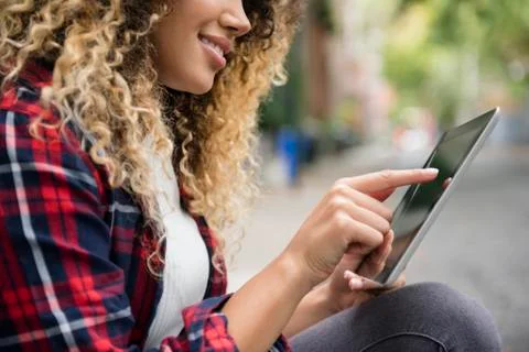 Mixed Race woman using digital tablet in city Stock Photos
