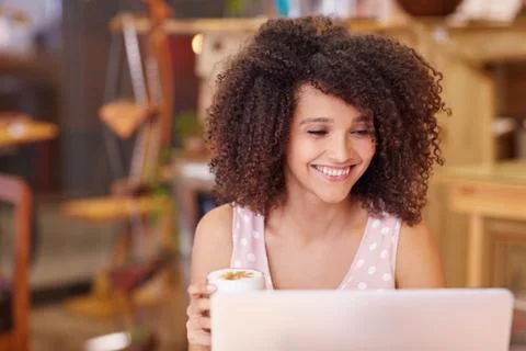 Mixed race woman using her laptop in a coffee shop Stock Photos