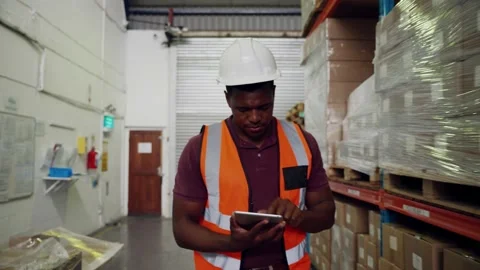 Mixed race worker checking list of digital tablet pointing to parcels on shelfs Stock Footage 140496728