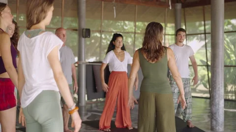 Mixed race yoga class stand with arms opened and meditate in large studio in the Stock Footage 217440453