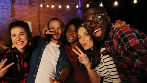 Mixed raced friends posing and making funny selfies at the party at night. Urban Stock Footage 81805920