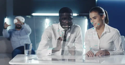 Mixed-races couple of workers sitting at table in front of transparent glass Stock Footage 130310693