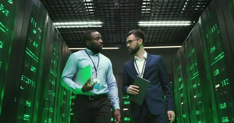 Mixed-races men engineers with tablet device. Software specialists walking at Stock Footage 137544942