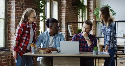 Mixed-races team of the start-up project workers discussing their future plans Stock Footage 101001420