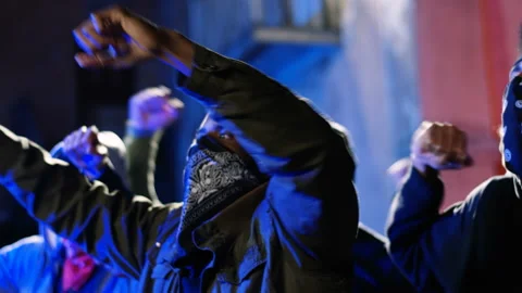 Mixed-races young men rebels with masked faces screaming mottos and shouting Stock Footage 132543029