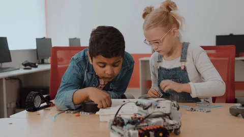 Mixed Racial group of School kids sitting at class with diy robot, stem Stock Footage
