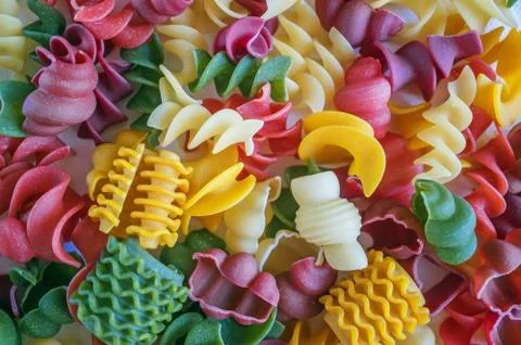 Mixed set of dry multi-colored Italian pasta on a white old wooden box Stock Photos