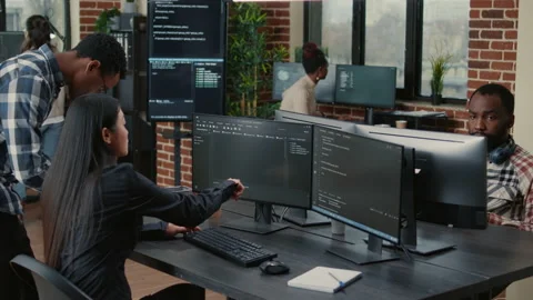 Mixed team of programmers analyzing source code pointing at screens comparing Stock Footage 168251346