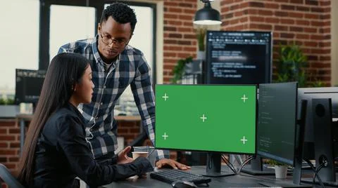 Mixed team of programmers analyzing source code looking at green screen chroma Stockfoto's