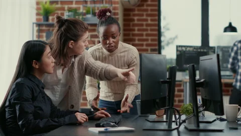 Mixed team of programmers brainstorming ideas for new code library in front of Stock Footage 168250649