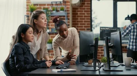 Mixed team of programmers brainstorming ideas for new code library in front of Stockfoto's