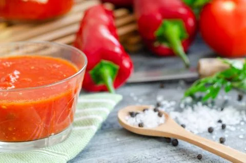 Mixed tomatoes and chilli sauce in bowl on table. Stock Photos