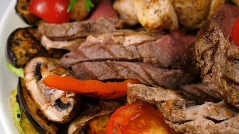 Mixed various grilled meat platter with vegetables, served in Restaurant Stock Footage 87568125