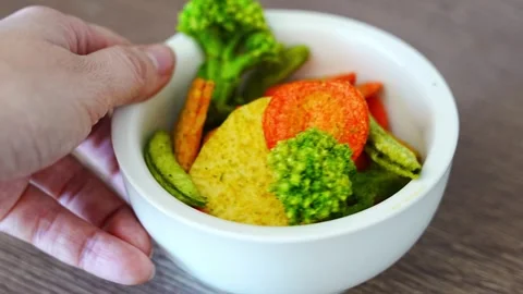 Mixed vegetable chips in bowl with broccoli, carrot, peas and sweet potato on Stock Footage 345658275