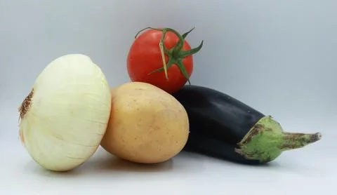 Mixed vegetable composition featuring a white onion, yellow potato, red tomato Stock Photos