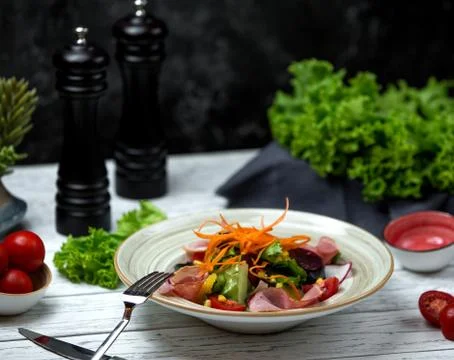 Mixed vegetable salad with slices of ham Stock Photos