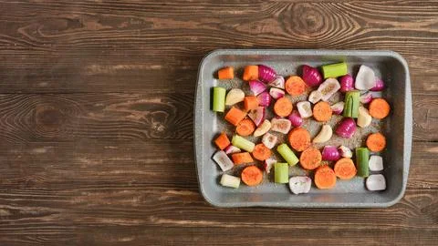 Mixed vegetables on a baking tray prepared for roasting in a kitchen enviro.. Stock Photos