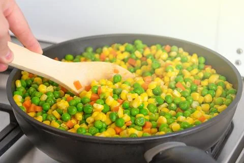 Mixed vegetables cooked in a frying pan. Peas, corn, carrots. Cooking. Health Stock Photos