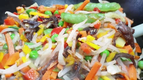 Mixed vegetables. Mix the chopped vegetables until they are cooked in a wok Stock-Footage 134538499