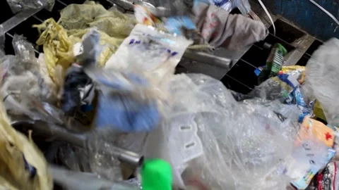 Mixed waste agitated on vibrating separation unit in recycling plant Stock Footage 333345343