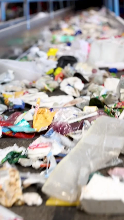 Mixed waste transported along primary conveyor line in recycling plant Stock Footage 333345261
