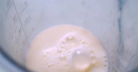 A mixer whips up a milkshake in a plastic cup Stock Footage 333577917