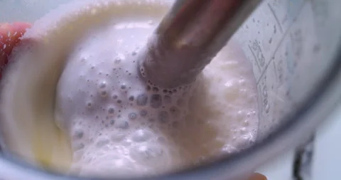 A mixer whips up a milkshake in a plastic cup Stock Footage 333577974