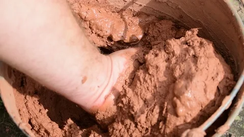 Mixes clay in a bucket Stock Footage 117420043