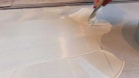 Mixing and applying thin-set mortar on a floor at a home renovation project Stock Footage 325175014