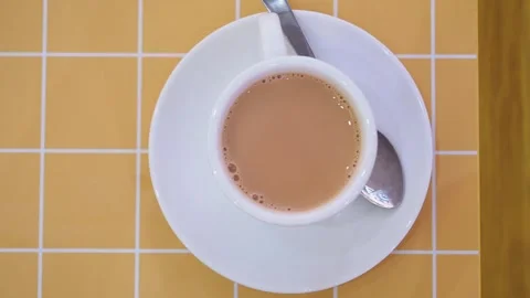 Mixing and enjoying tea in a cup at a cafe table in the afternoon Stock Footage 345964469