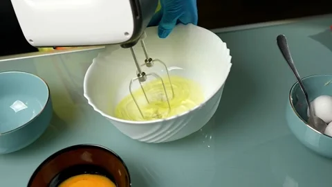 Mixing the batter thoroughly using an electric beater Vidéo 295761408