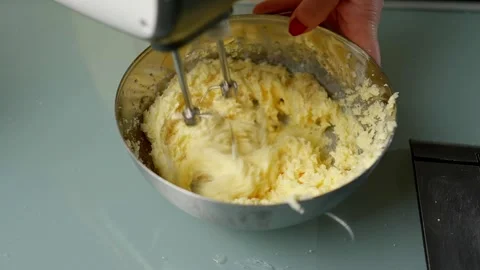 Mixing the batter thoroughly using an electric beater Vidéo 295761434