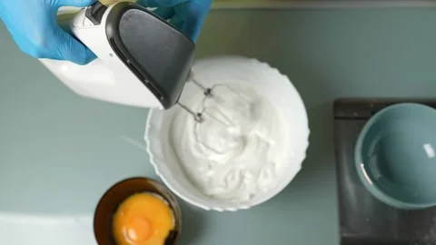 Mixing the batter thoroughly using an electric beater Vidéo 295761484