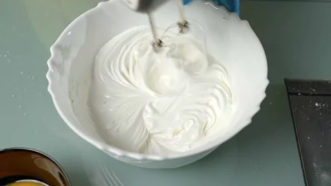 Mixing the batter thoroughly using an electric beater Vidéo 295761742