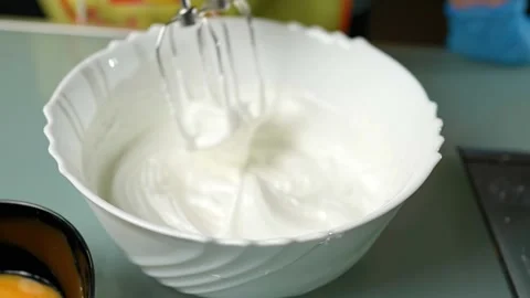 Mixing the batter thoroughly using an electric beater 库存影片 295761880