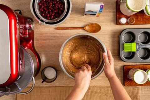 Mixing the batter using fork and other ingredients for muffin making Stock Photos