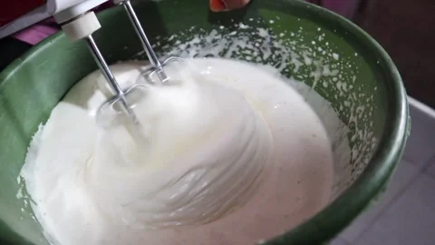 Mixing cake batter with an electric mixer, creating a smooth and creamy tex.. Stock Footage 303200729