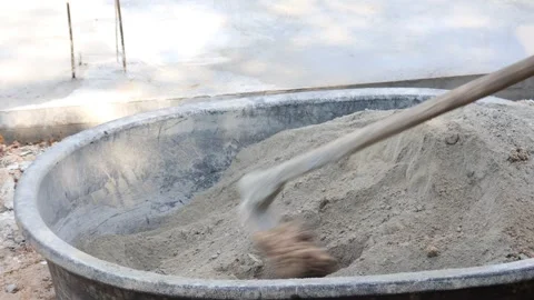 Mixing of cement and sand in large containers for use in construction demonstrat Stock Footage 343699057