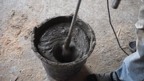 Mixing cement for construction in a small black tank. Worker mixing plaster. Stock-Footage 123542503